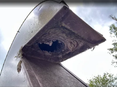 Lint-packed dryer vent at the roof cap